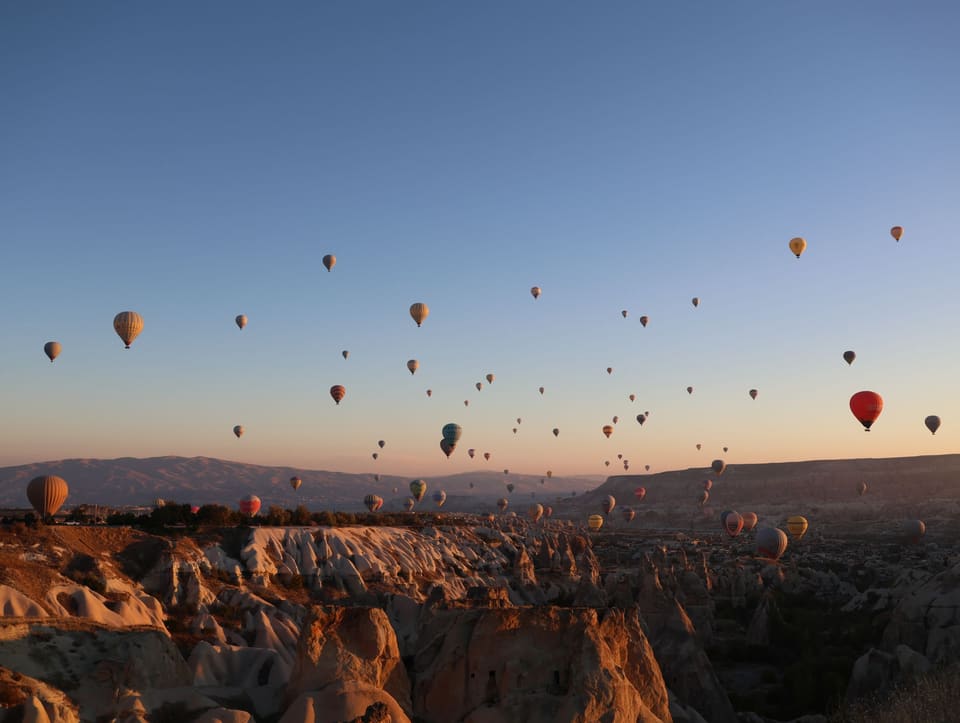 Dozens of hot air balloons over the fairy chimneys at dawn
