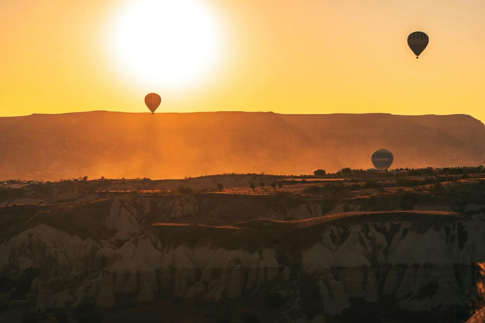 Balloons drifting over the valleys against the rising sun
